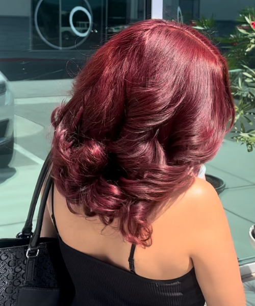 A woman with red hair carrying a black purse