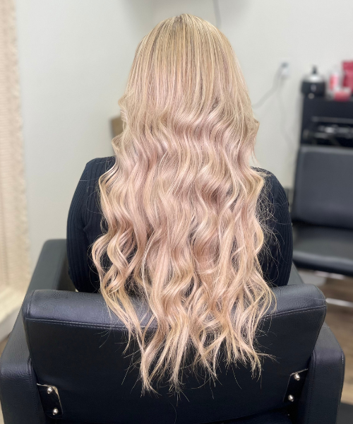 A woman with long blonde hair sitting in a chair