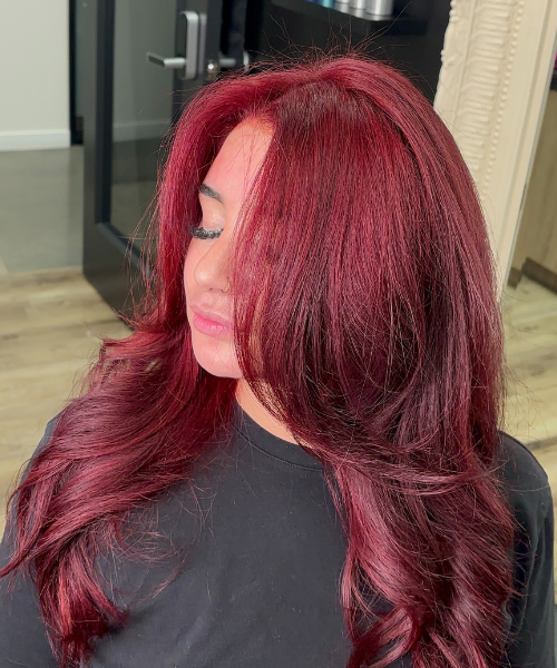 A woman with long red hair and a black shirt